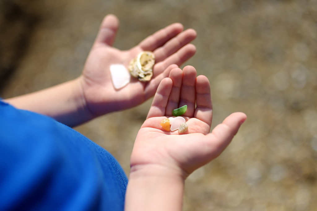 child's open hands both holding pebbles