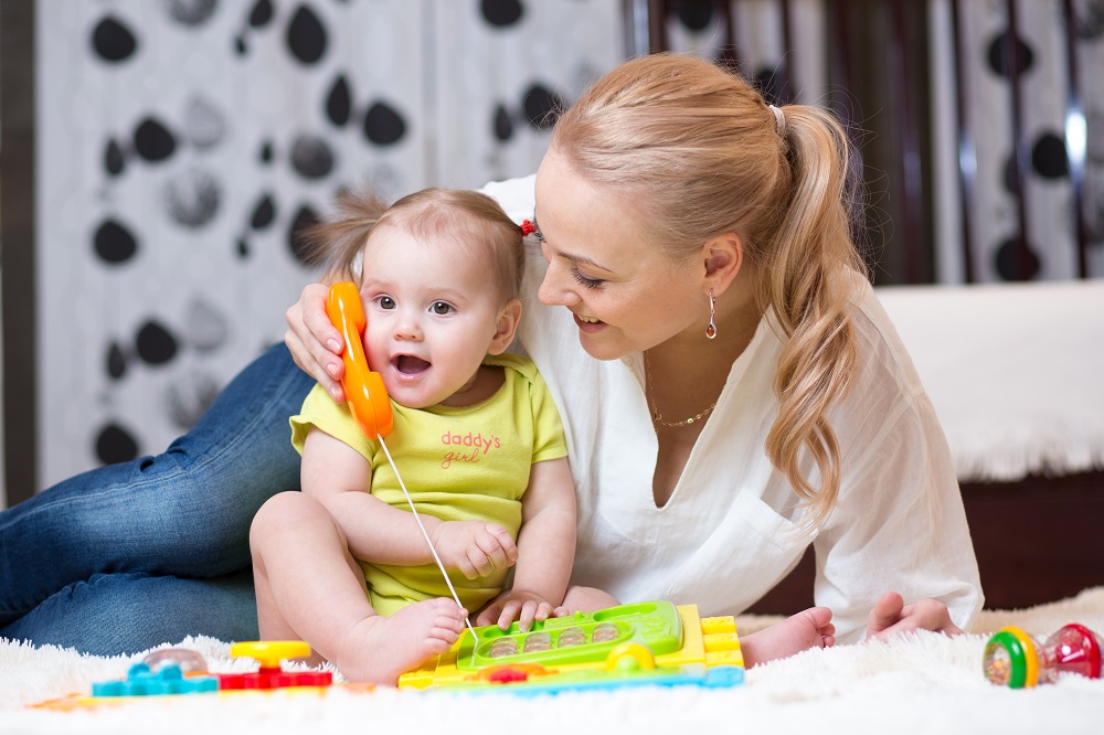 white mother and child paying with a toy telephone